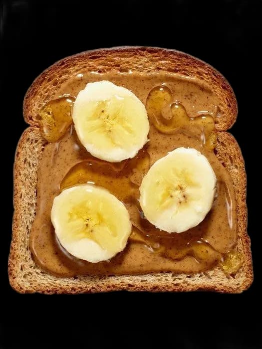 slice of toast with peanut butter, banana and honey